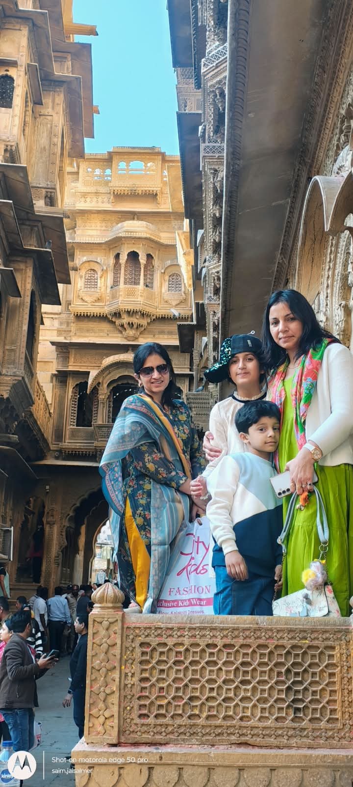 Family on a carved haveli balcony